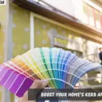 A person holds a paint color sample in front of a house, contemplating a fresh look for their home.