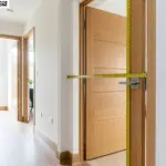 Door Size measurement with tape across wooden interior door frame