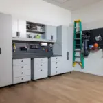 Modular garage storage systems featuring grey cabinets, a pegboard with organized tools, and bicycles.