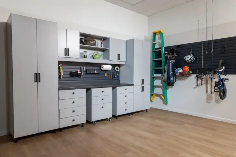 Modular garage storage systems featuring grey cabinets, a pegboard with organized tools, and bicycles.