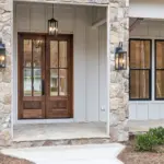 Entrance of a modern new-build house with stone facade and wooden double doors