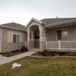 A suburban house with patches of snow on the lawn in winter